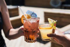 Two people clinking their cocktails in celebration