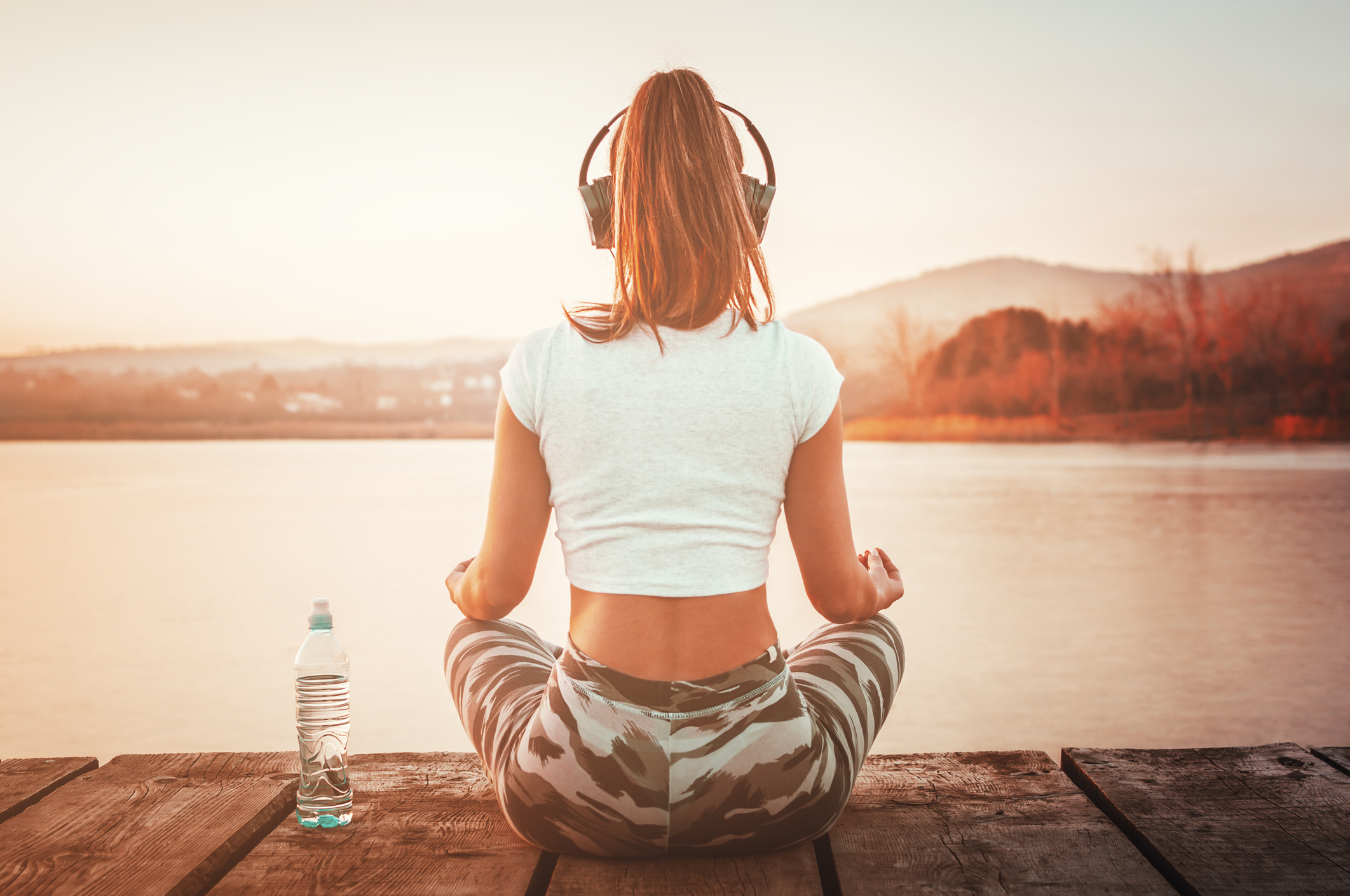 woman practicing yoga whilst listening to music