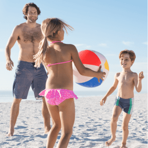 Family on beach playing with a beach ball.