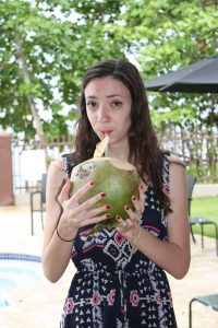 Woman drinking from a coconut poolside at Maria's Luxury villa