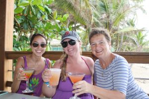 Three women enjoying mixed drinks.