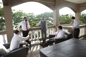 Groomsmen and groom chatting on balcony of Maria's Villa PR
