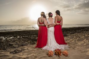 Bride and bridesmaids looking out over the ocean.