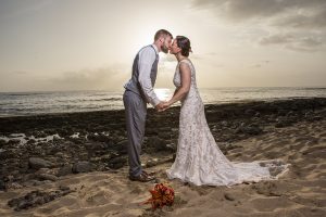 Wedding couple kissing on beach.