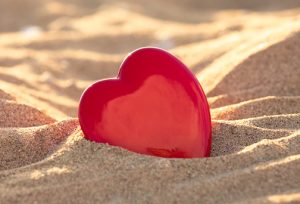 Glass heart in the sand