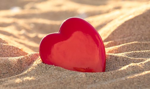 Glass heart in the sand