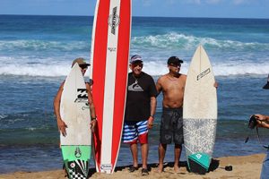 Surfers posing on beach with their boards.